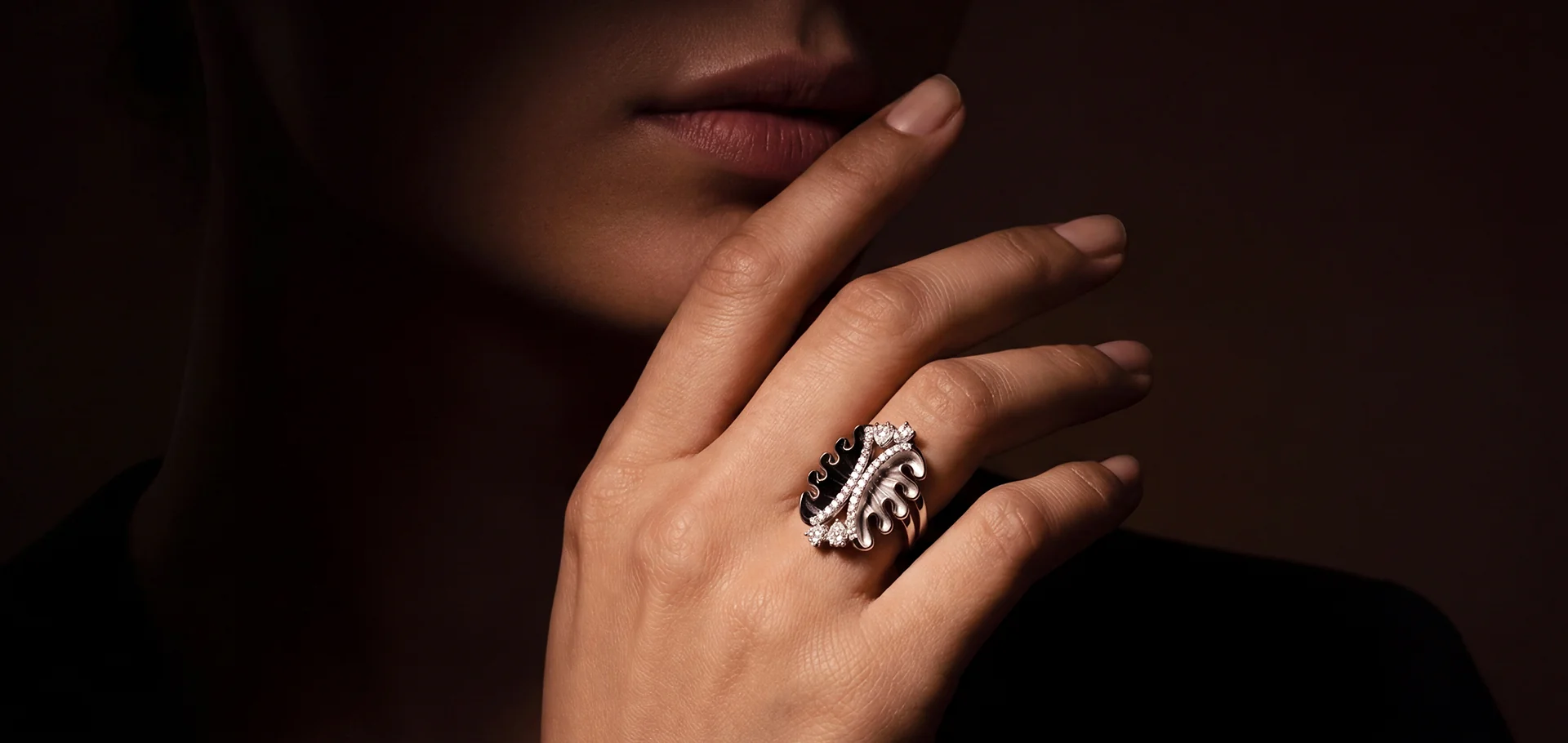 The Eclipse ring in black and white diamonds, held to the lips